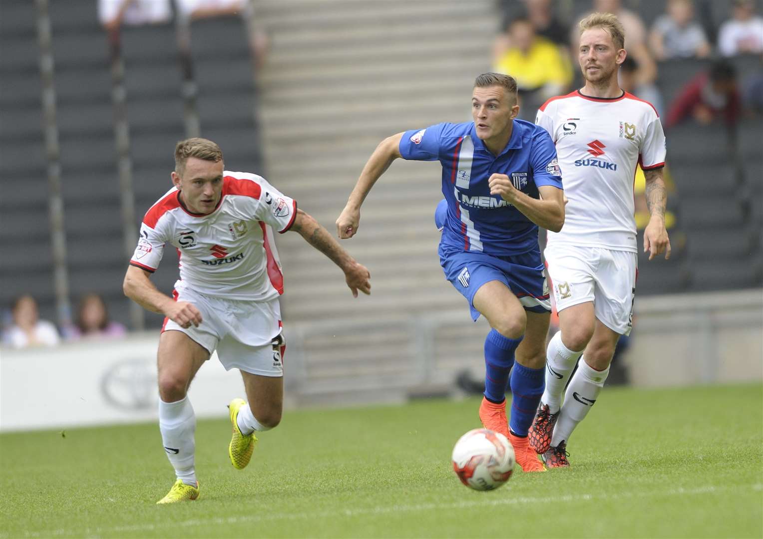 Lee Hodson (left) gives chase when playing against the Gills for MK Dons back in 2014 Picture: Barry Goodwin