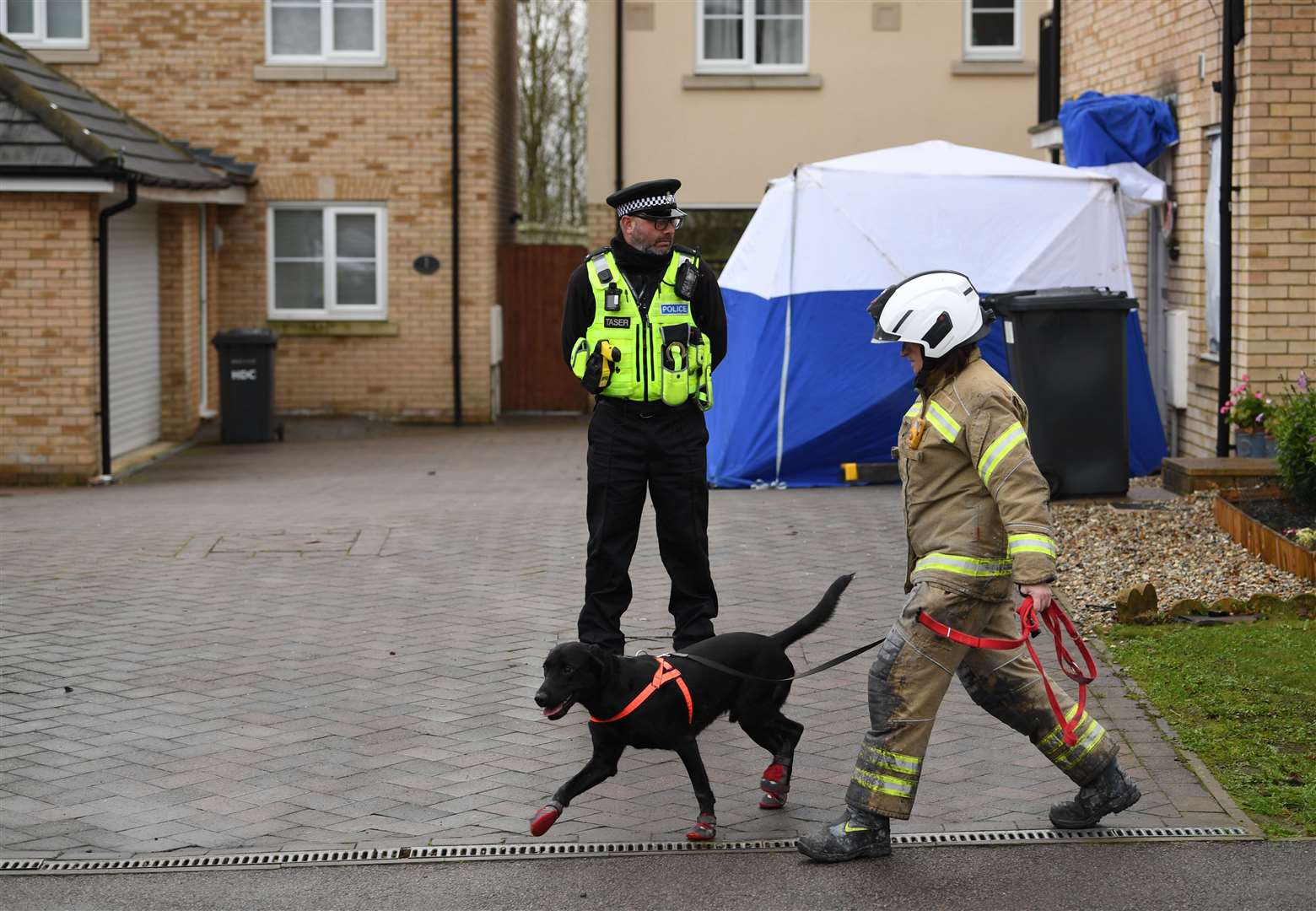 The fire service dog unit attended as investigations continue into the cause of the fatal house fire (Joe Giddens/PA)