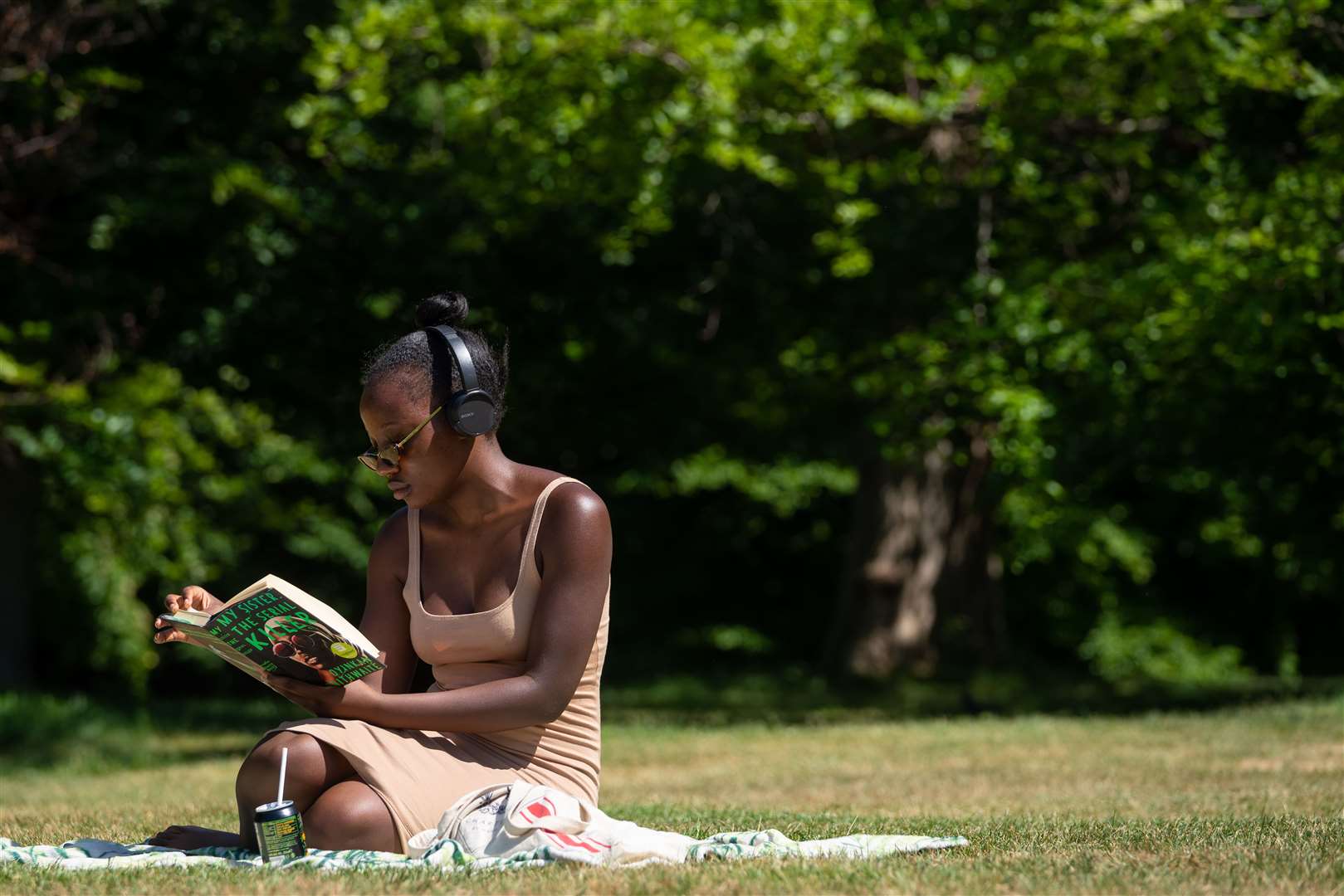 A woman reads a book in Greenwich Park, London (Dominic Lipinski/PA)