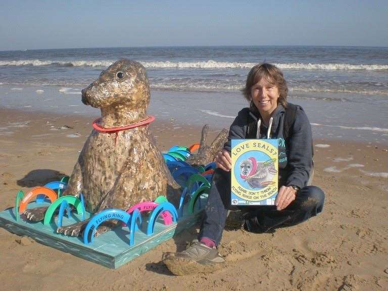 Campaign co-ordinator Jenny Hobson with the sculpture of a seal with a flying ring stuck round its neck (Richard Hobson/ Friends Of Horsey Seals/ PA)