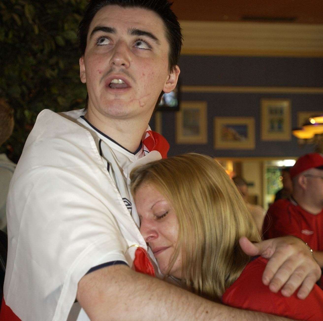 Fans console each other after the final whistle as England lose to Brazil in the 2002 World Cup