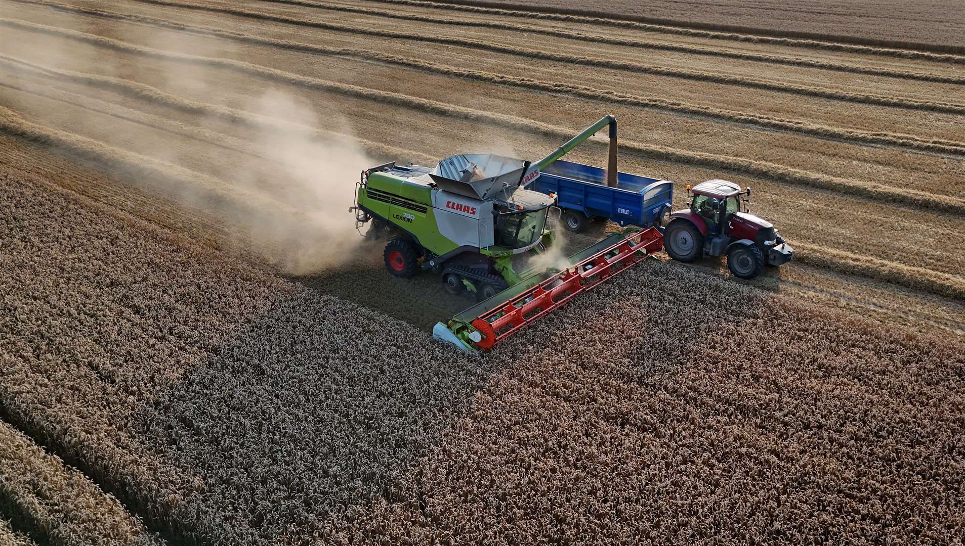 A combine harvester gathers crops during the evening sunshine on the Romney Marsh near Ashford in Kent (Gareth Fuller/PA)