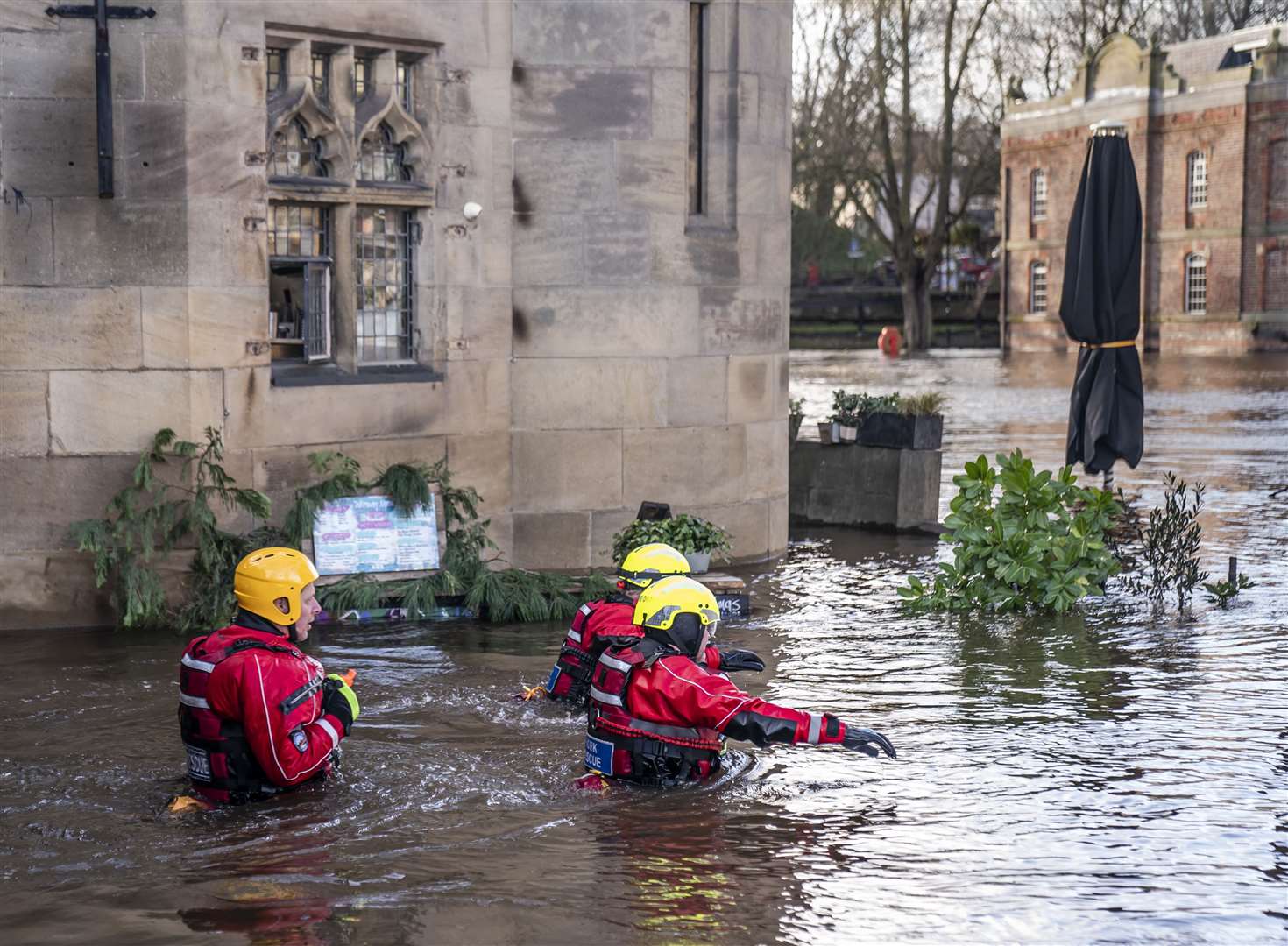 Rescue workers wade through floodwater in the centre of York after the River Ouse burst its banks (Danny Lawson/PA)