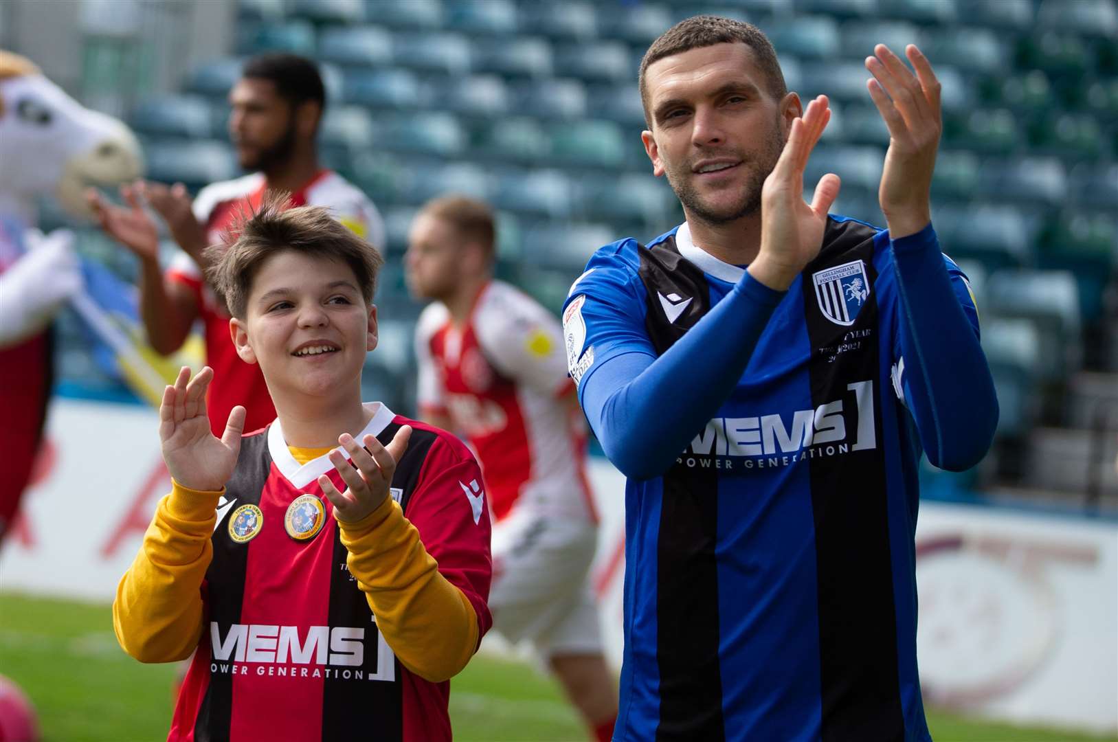 Ukrainian refugee Daniel Lysak leads Gillingham out with captain Stuart O'Keefe. Picture: KPI