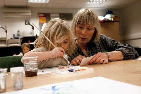 Milla Morgan, three, gets help from her mother to make an I Love Whitstable postcard for the exhibition