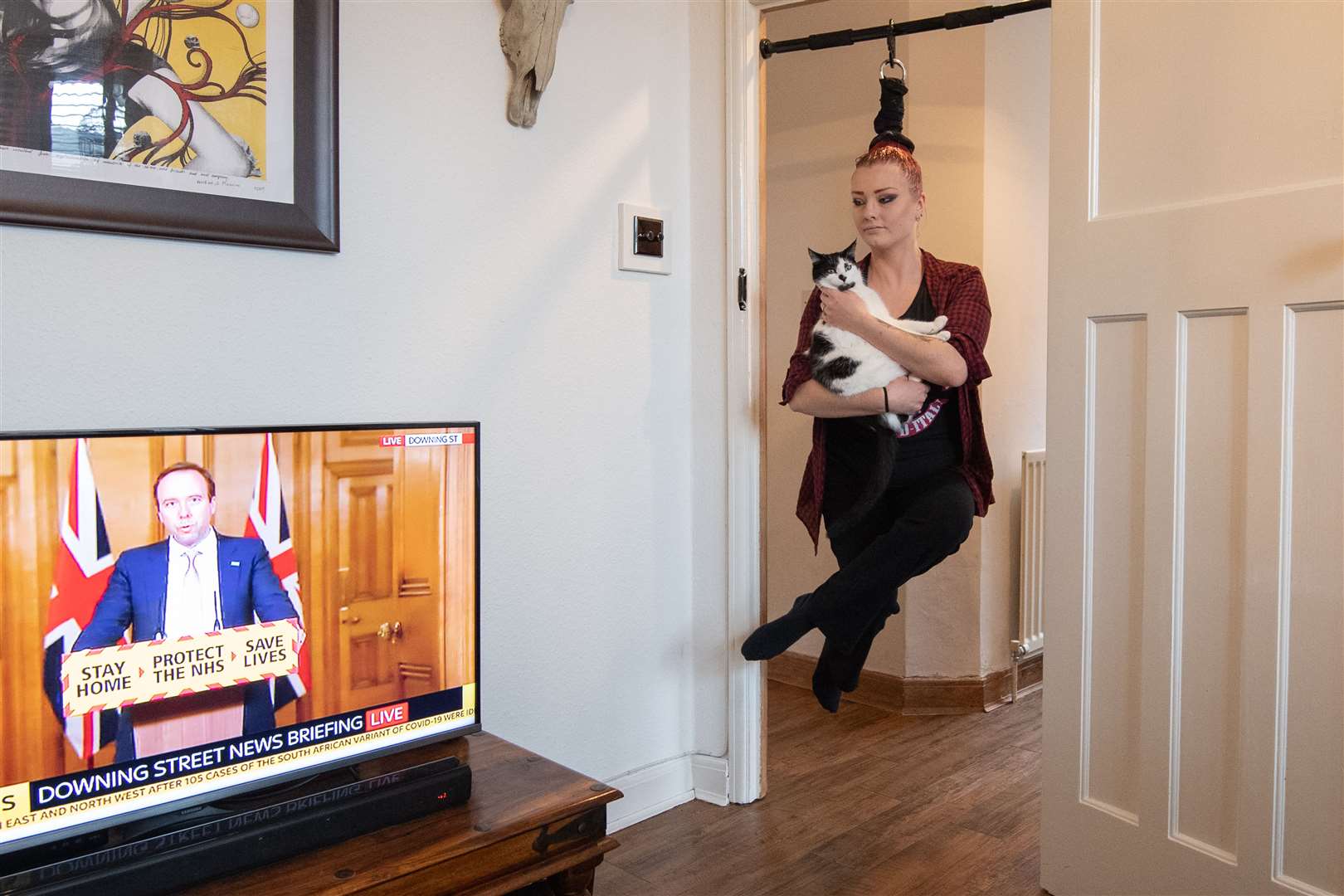 Circus performer Anastasia Sawicka practises her ‘hair hanging’ skills at her home in Northampton (Joe Giddens/PA)