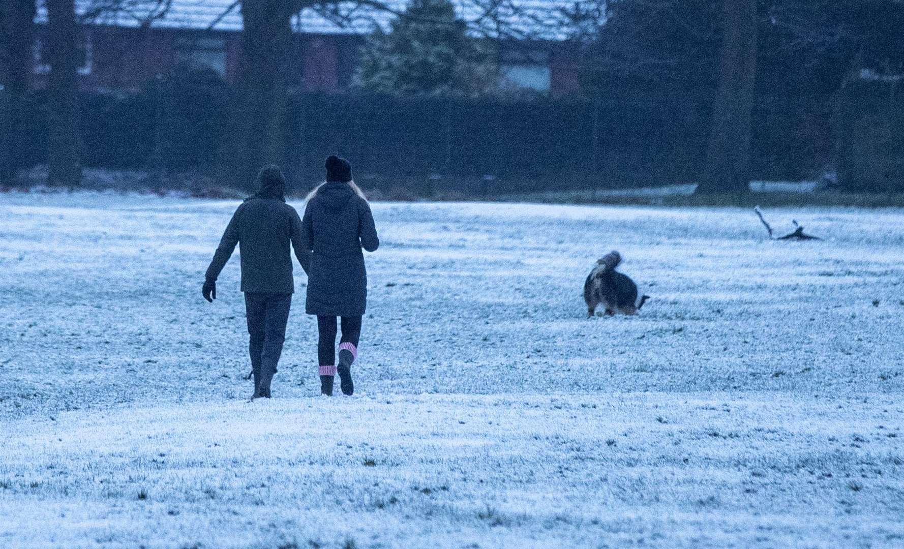 People walk their dog through the snow in Woolton, Liverpool (Peter Byrne/PA)