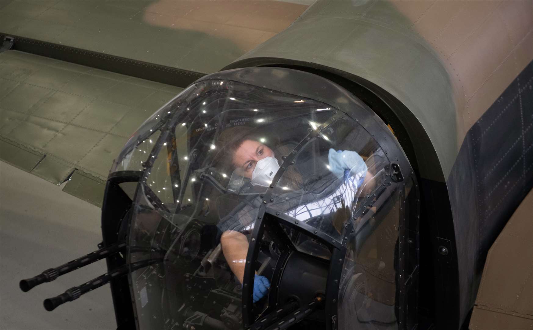 Preventive conservator Samantha Archetti cleans the rear gun turret of an Avro Lancaster Bomber at the Imperial War Museum Duxford (Joe Giddens/PA)