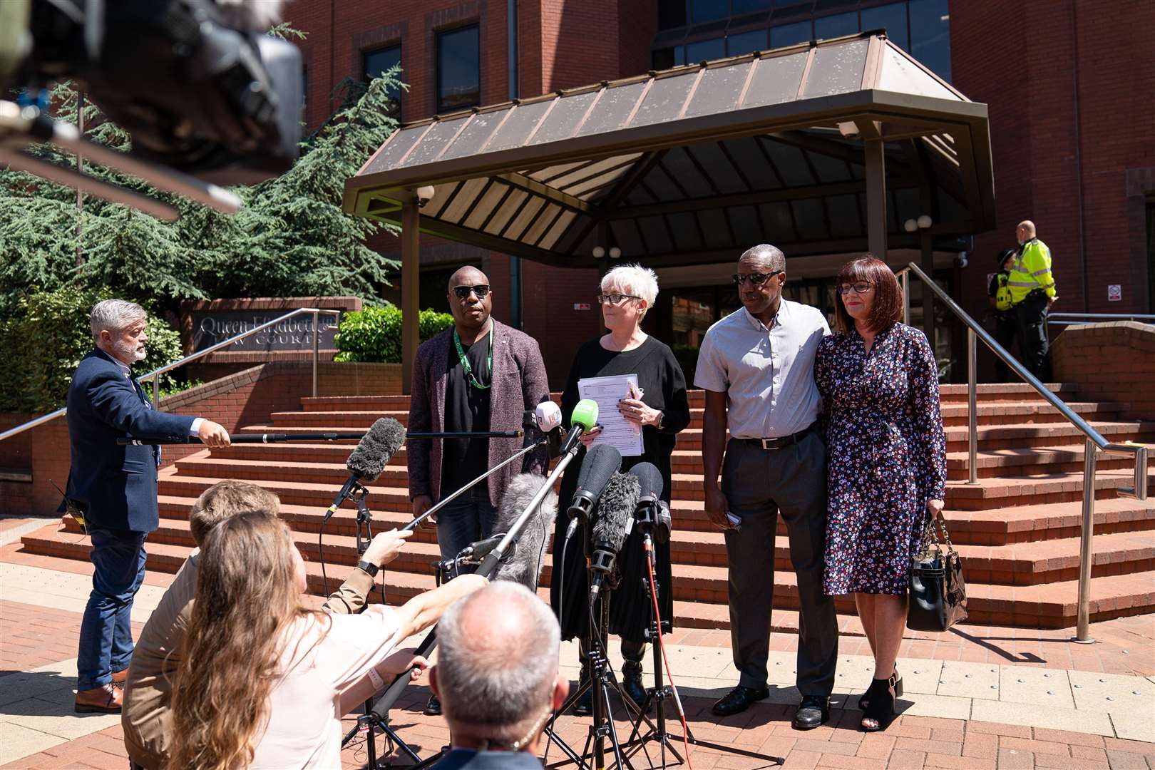 Legal representatives for the Atkinson family read a statement alongside Kenroy Atkinson, brother of Dalian, and his wife Julie (R), outside Birmingham Crown Court. West Mercia Police constable Benjamin Monk was found guilty of the manslaughter of ex-footballer Dalian Atkinson but cleared of his murder (Joe Giddens/PA).