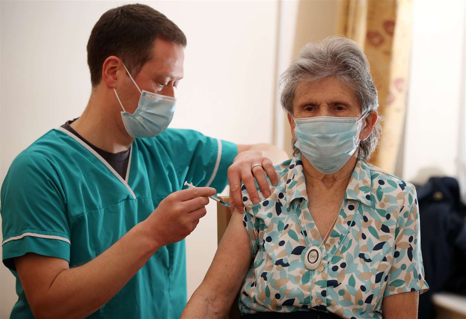 Dr Maurice Price administers the BioNTech/Pfizer Covid-19 vaccine to Beryl Humphreys at Bowbrook House care home in Shrewsbury (Nick Potts/PA)