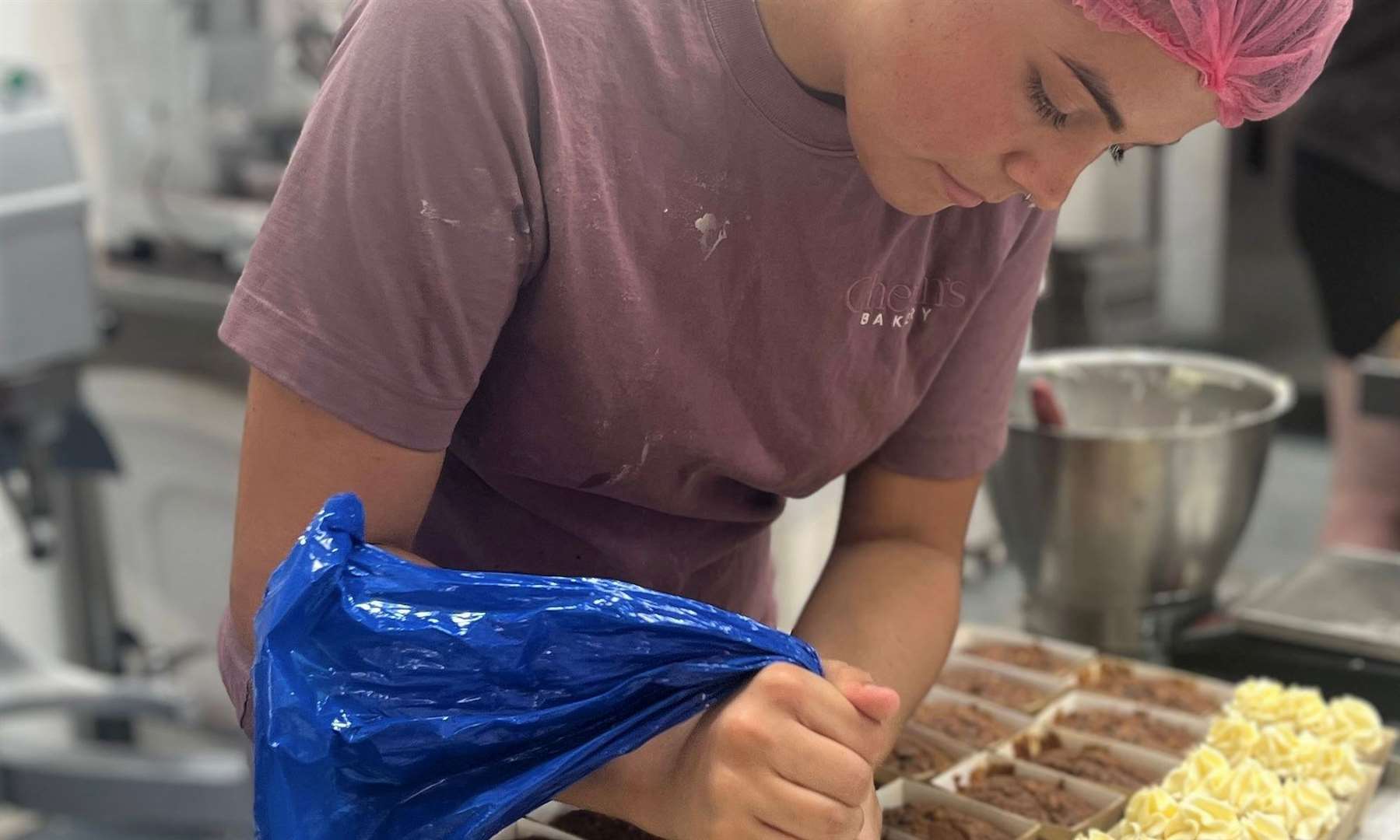 Brooke Parker, from Minster, piping icing onto carrot cakes. Picture: Megan Carr