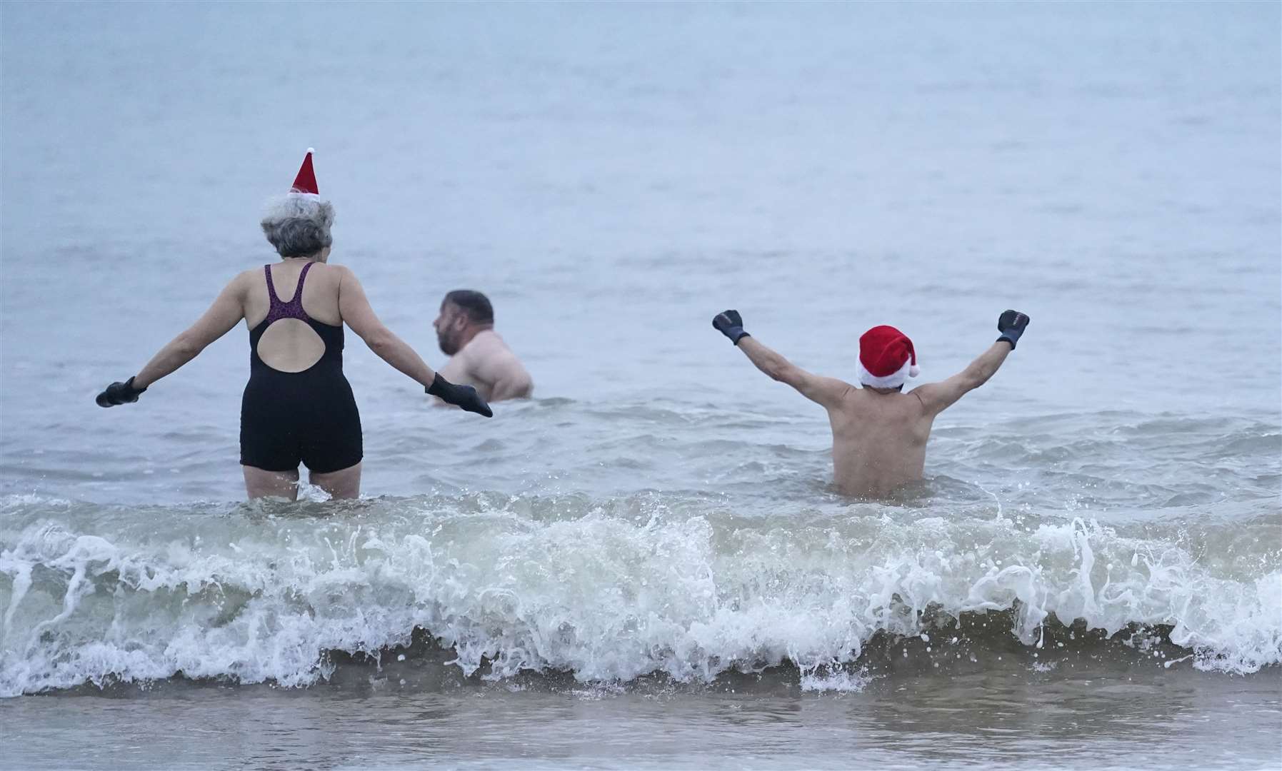 Swimmers take part in an early Christmas Day dip on Boscombe beach in Dorset (Andrew Matthews/PA)