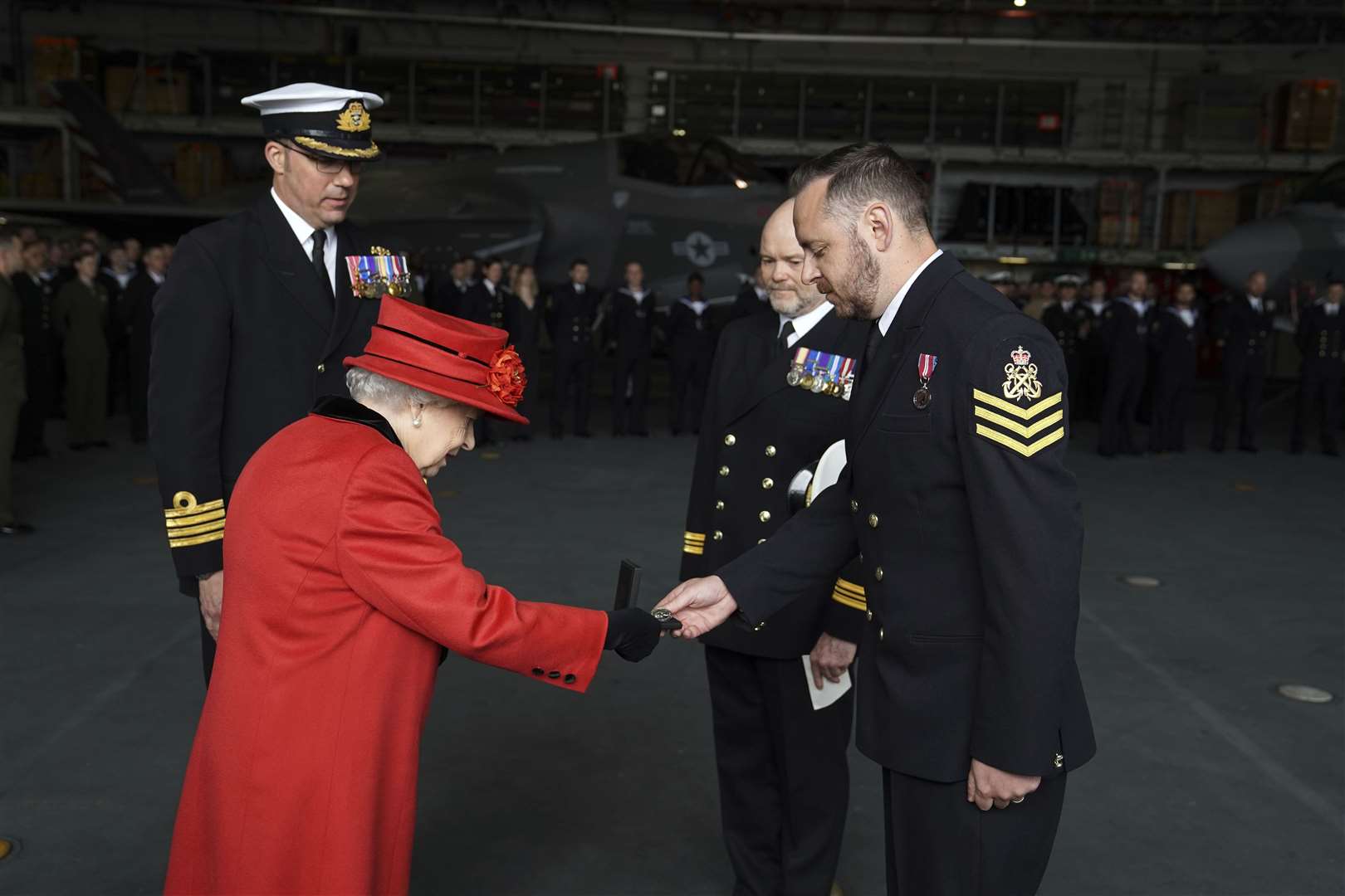 The Queen presents the 15 years long service and good conduct medal to Petty Officer Matthew Ready (right) (Steve Parsons/PA)