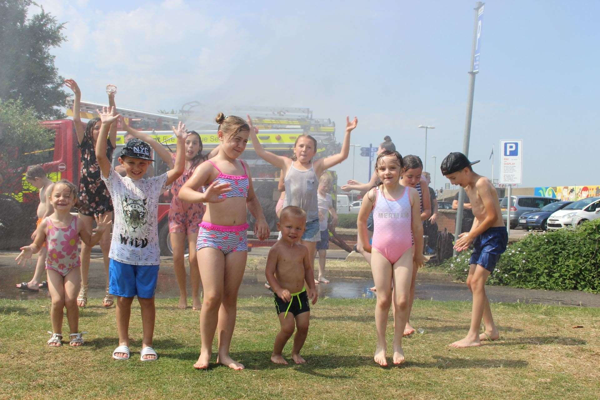 Youngsters dance in a water spray privided by Sheppey firefights in Beachfields Park, Sheeerness. Picture John Nurden (14293456)