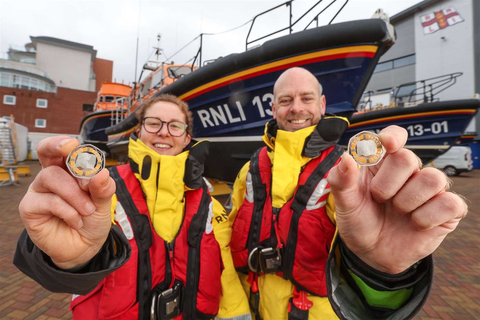 Lauren Baker-Little and Steve Porter of the RNLI show off the coin (Stuart Martin/Royal Mint/PA)