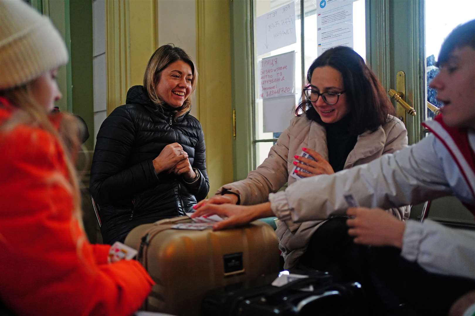 A family from Ukraine play cards at the station (Victoria Jones/PA)