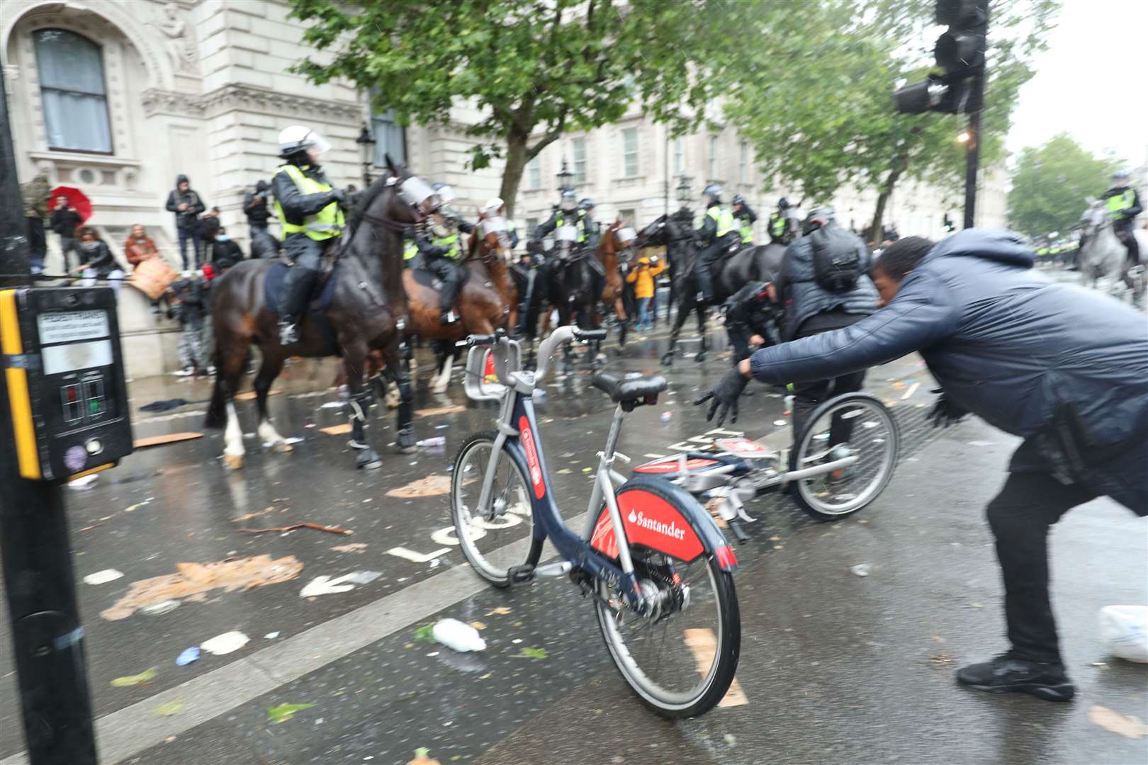 A bicycle is thrown at mounted police Police on horseback in Whitehall following a Black Lives Matter protest rally in Parliament Square, London (Yui Mok/PA)