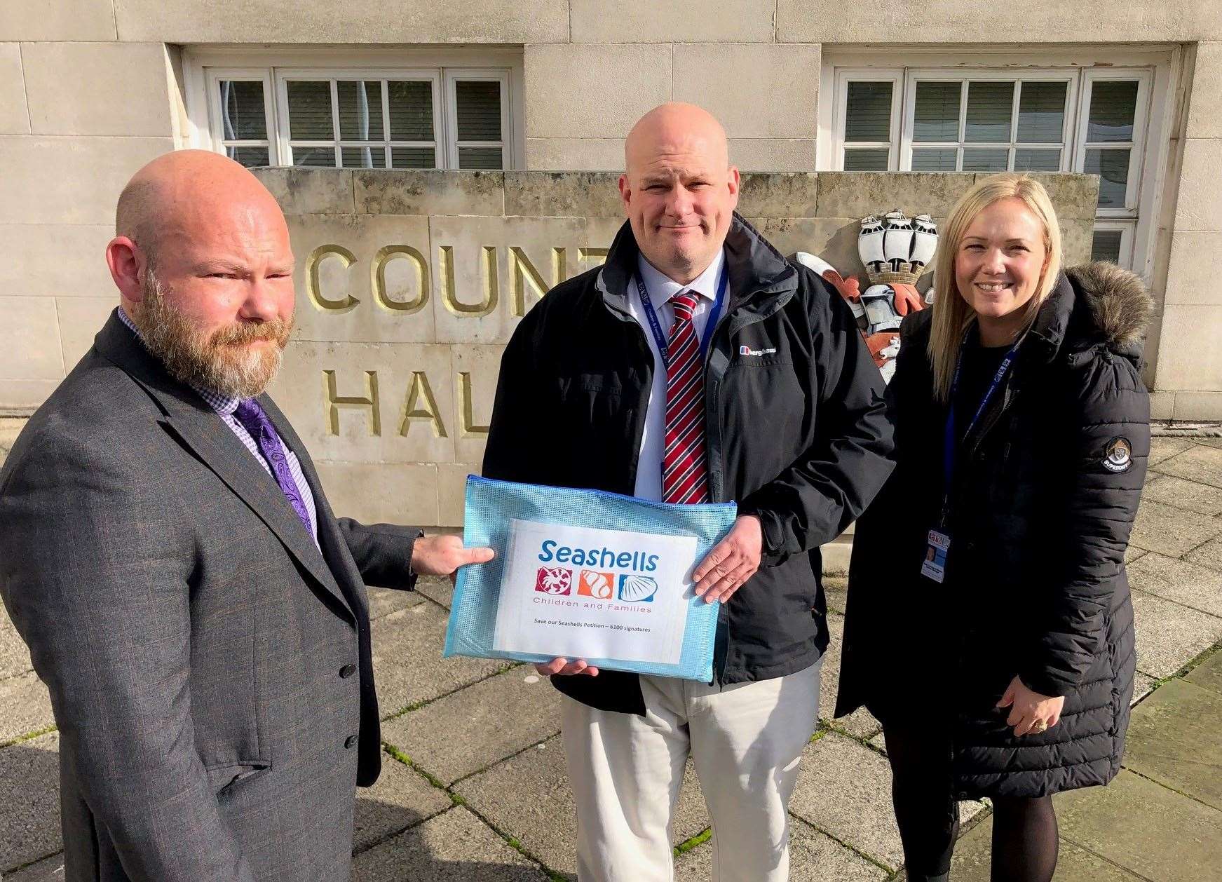 Seashells boss Jim Duncan and manager Kate Townsend-Blazier hand the petition to KCC officer Joel Cook outside County Hall in Maidstone. Picture: Seashells