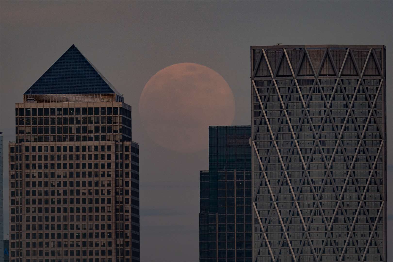 A pink supermoon is rises over Canary Wharf, London (Aaron Chown/PA)