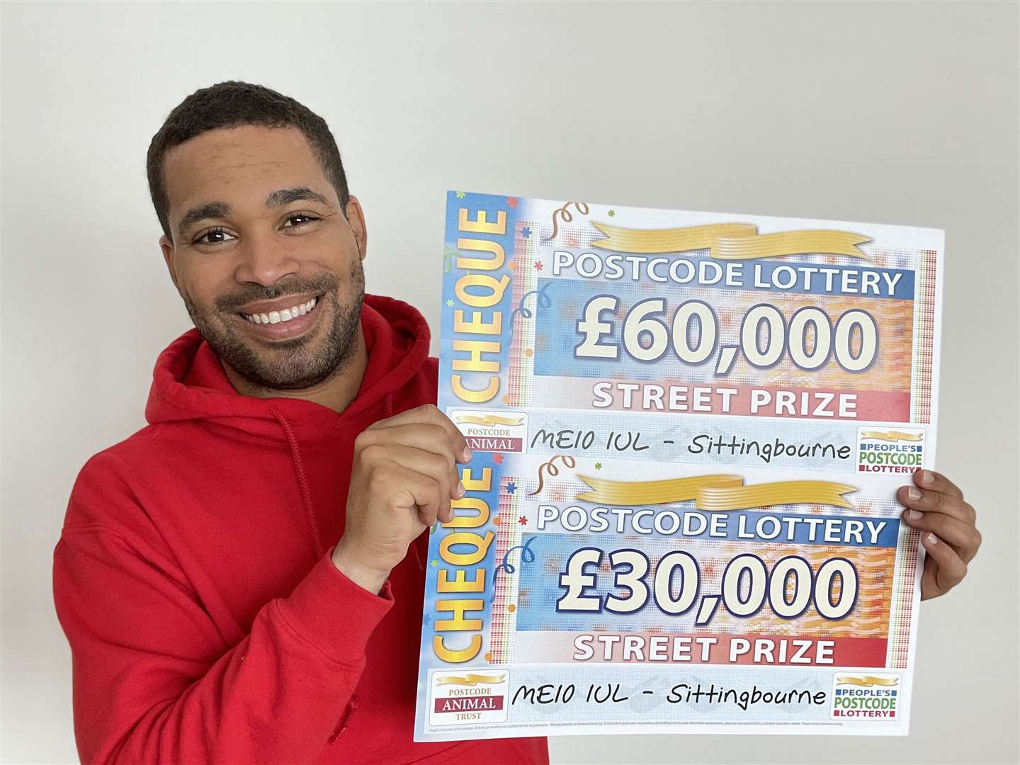 People's Postcode Lottery ambassador Danyl Johnson with the cheques