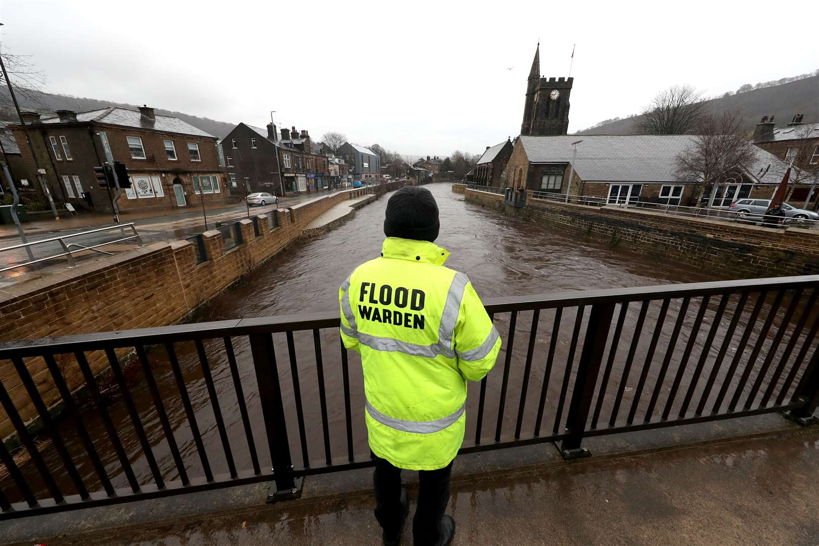 A flood warden looks at the water levels of the River Calder in Mytholmroyd in the Upper Calder Valley in West Yorkshire (Danny Lawson/PA)