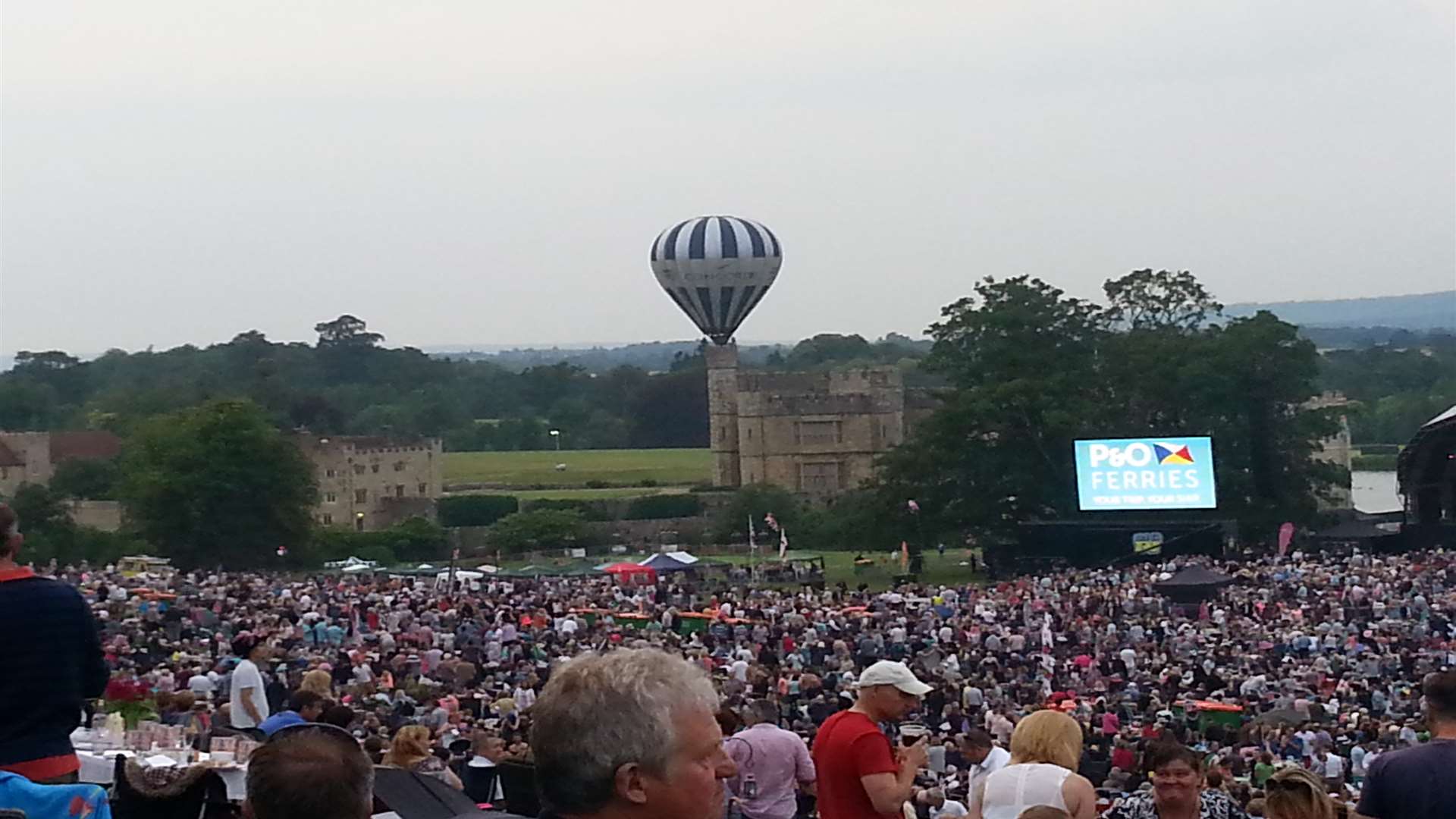 A hot air balloon floats gracefully over Leeds Castle