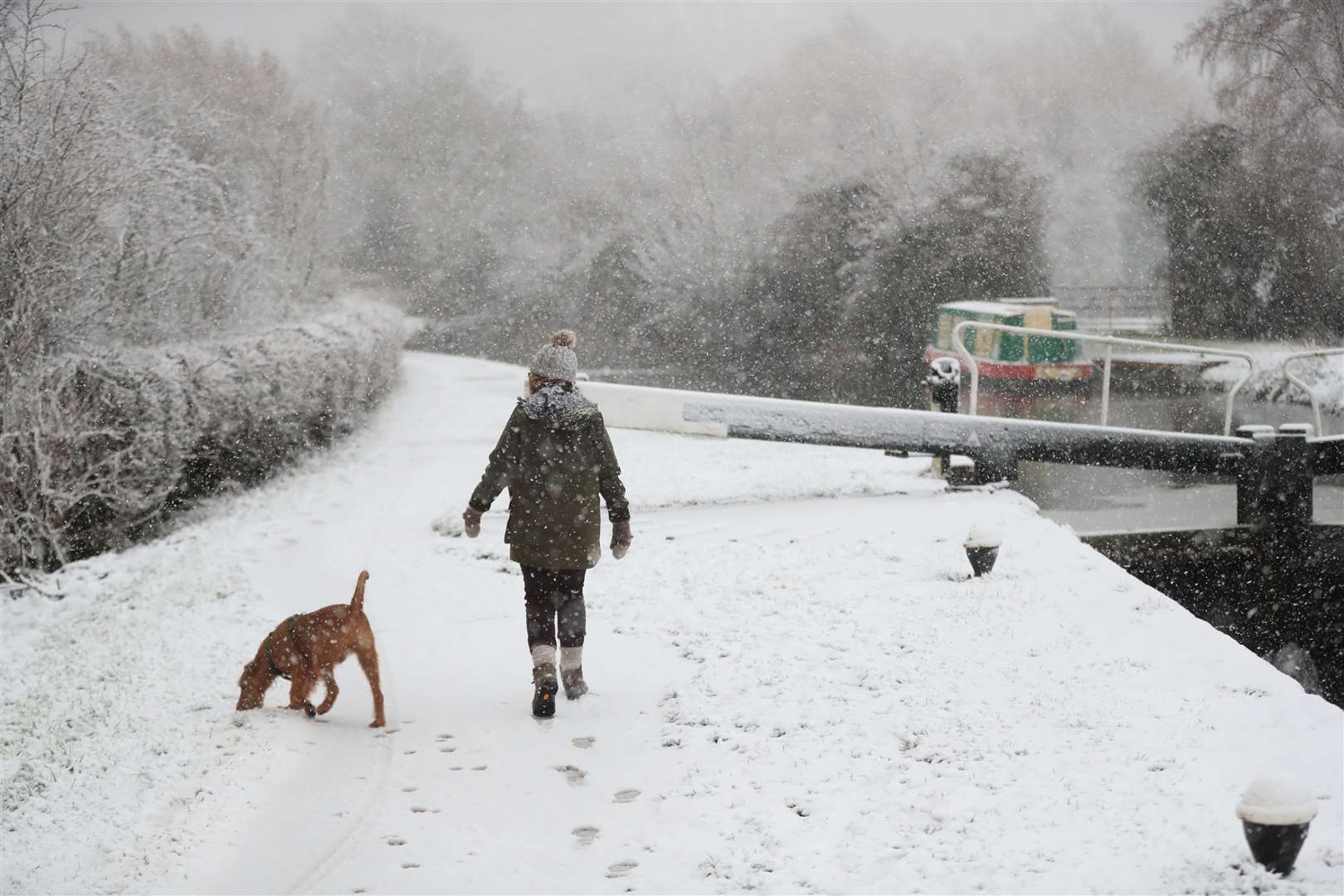 A dog walker braves the snow at Woolsthorpe Locke (Mike Egerton/PA)