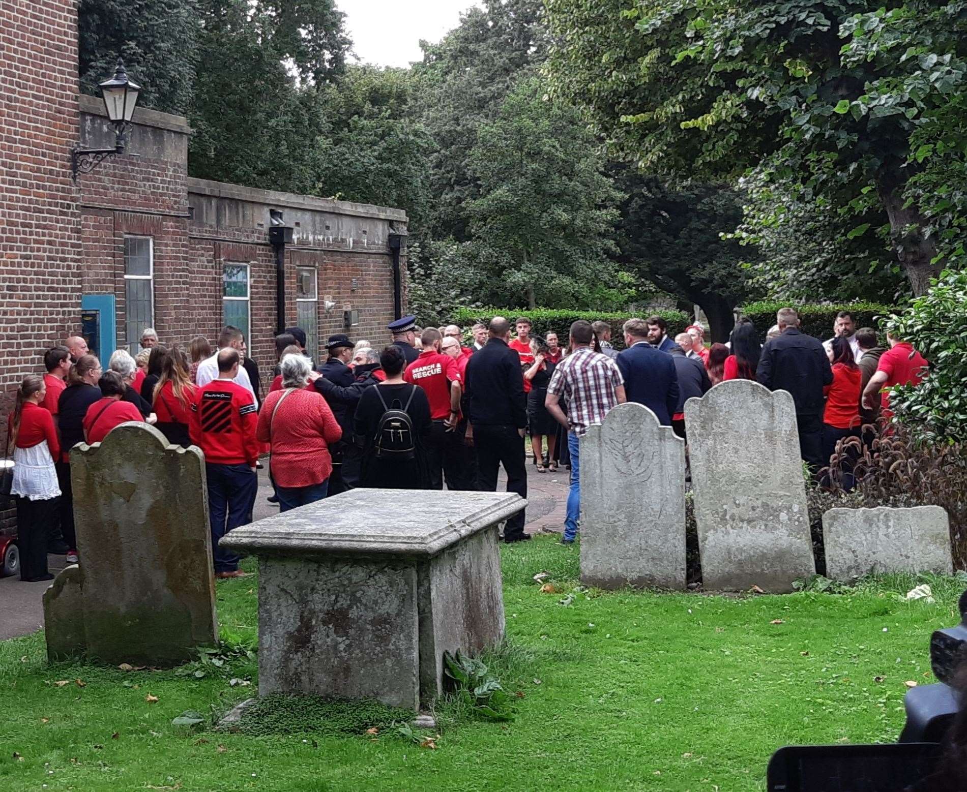 Mourners dressed in red at the church