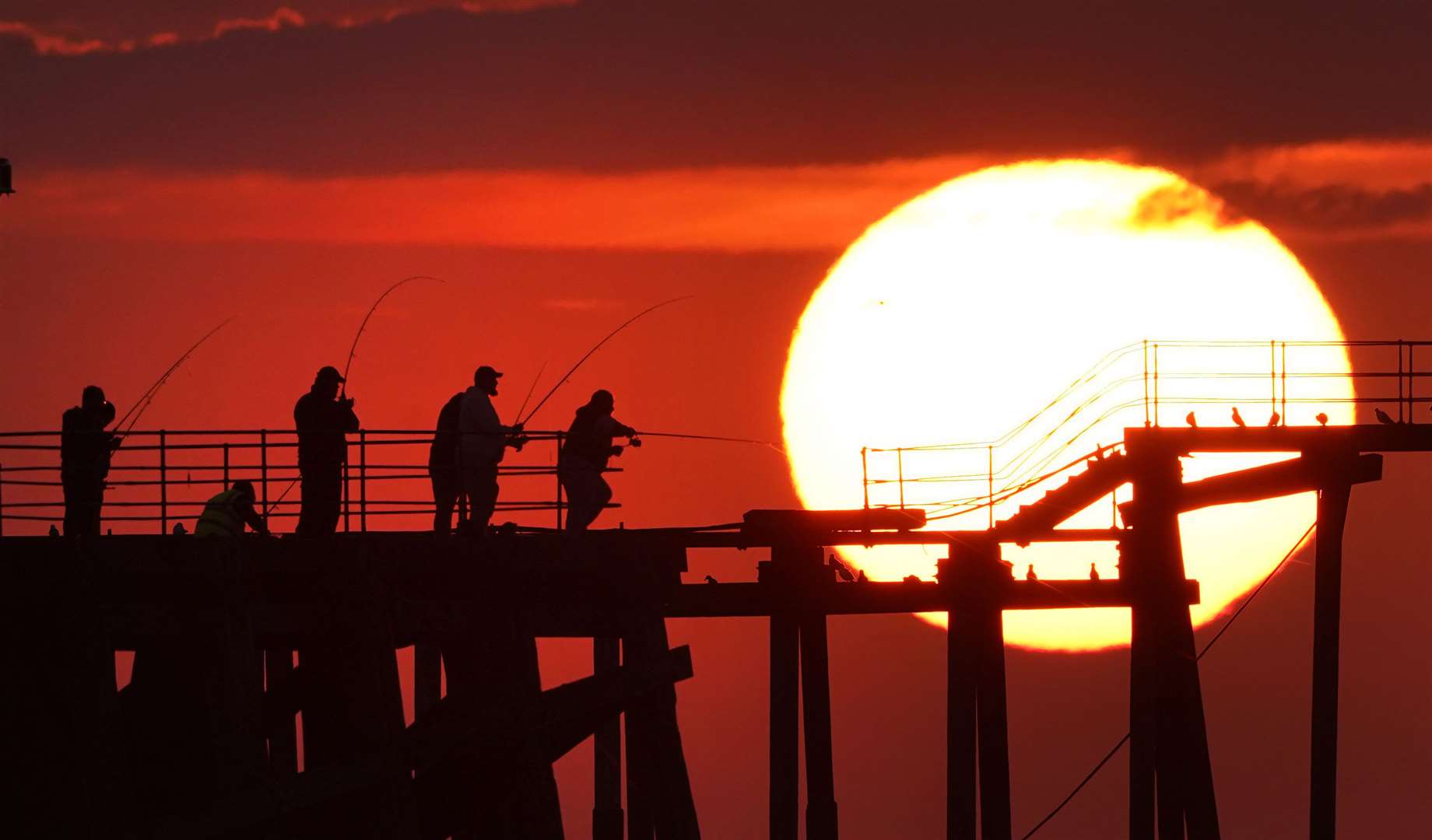 Anglers, hoping to catch mackerel and other fish, cast from the end of Blyth pier in Northumberland (Owen Humphreys/PA)