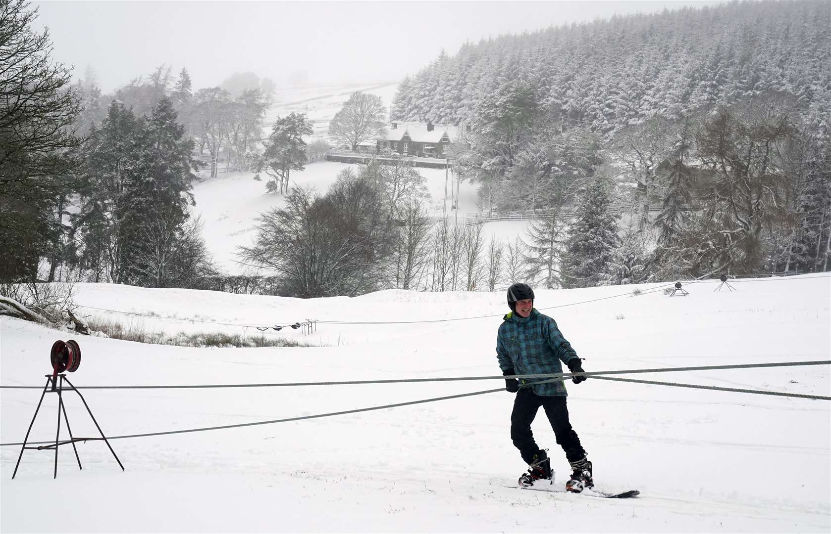 A snowboarder takes to a hill in Northumberland (Owen Humphreys/PA)