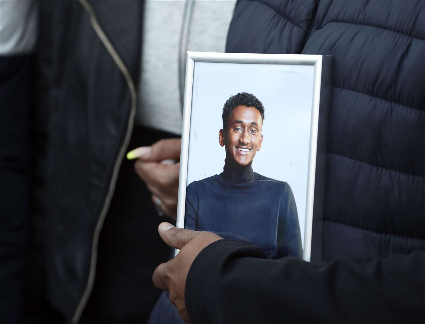 Chandima Daniel, father of Tashan Daniel, who was stabbed at Hillingdon station whilst on his way to an Arsenal game on Tuesday, holds a photograph of his son (Steve Parsons/PA)