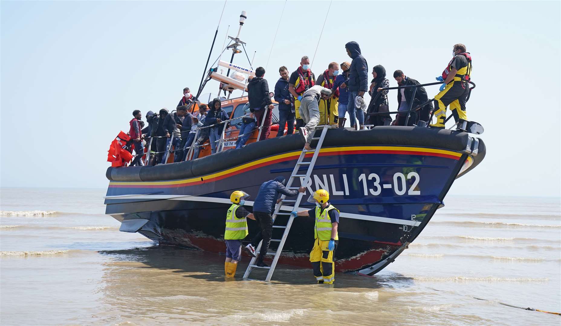 A group of people come ashore from the local lifeboat at Dungeness in Kent (Gareth Fuller/PA)