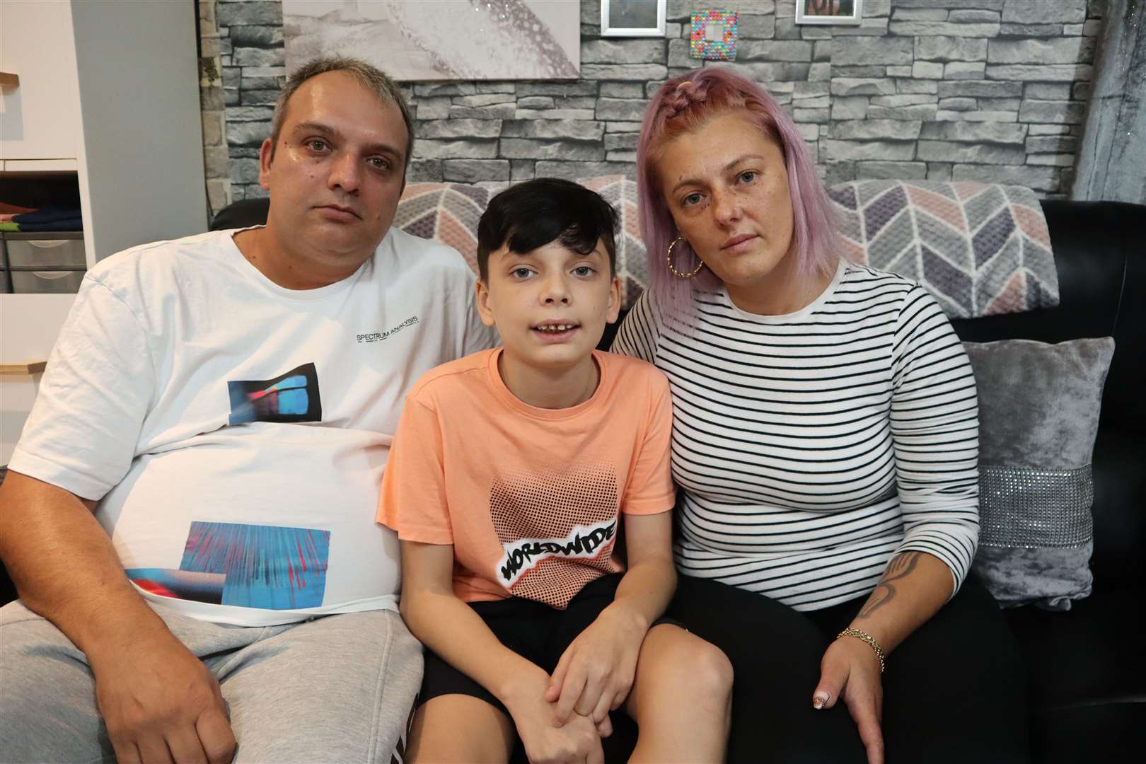 Denis-Cristian Bulancea with his dad Dumitru-Daniel and mum Petruta-Costina after the 12-year-old's front tooth was ripped out on a castle slide at Beachfields, Sheerness. Picture: John Nurden