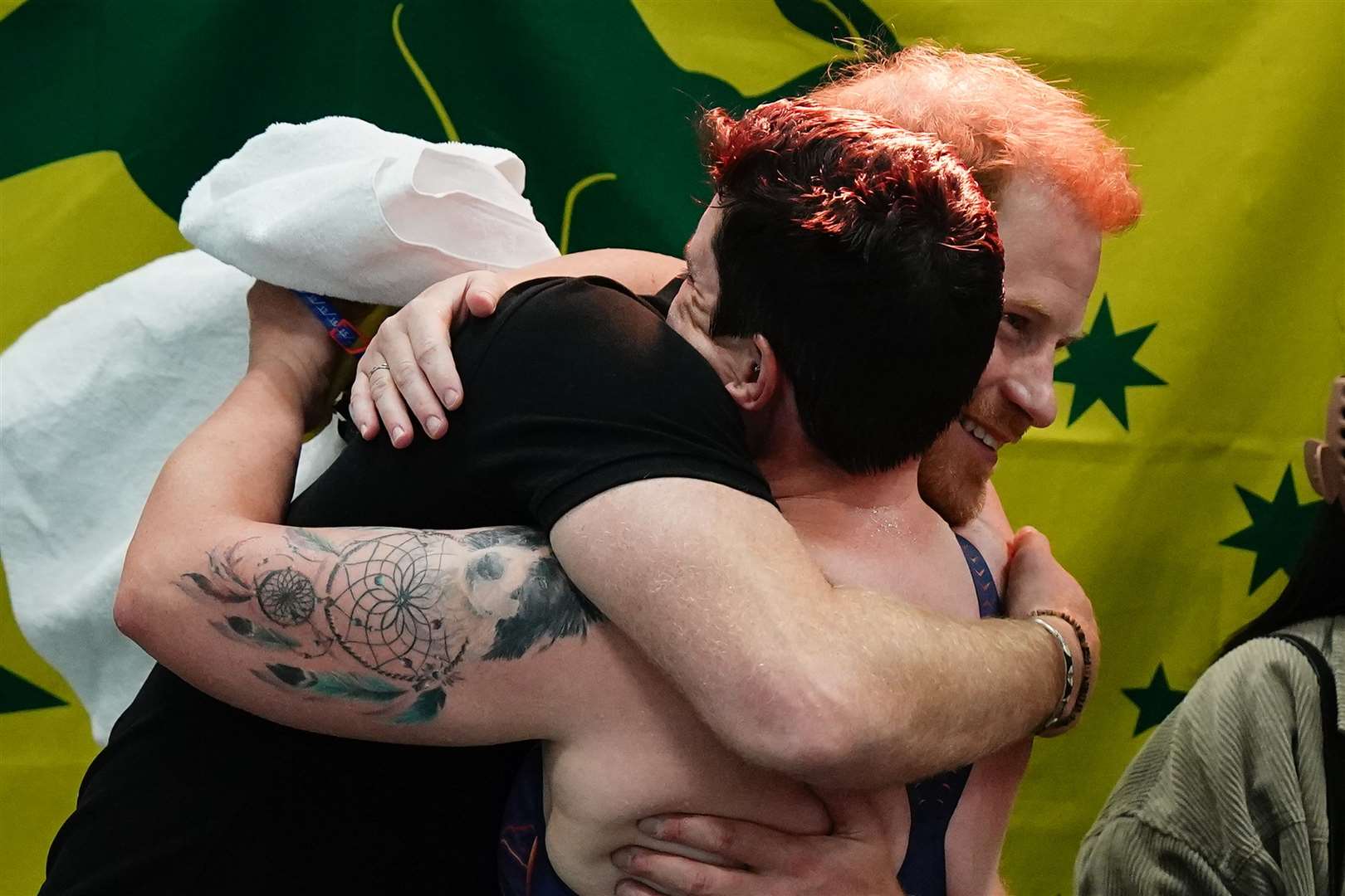 The Duke of Sussex hugs a competitor during the swimming (Aaron Chown/PA)