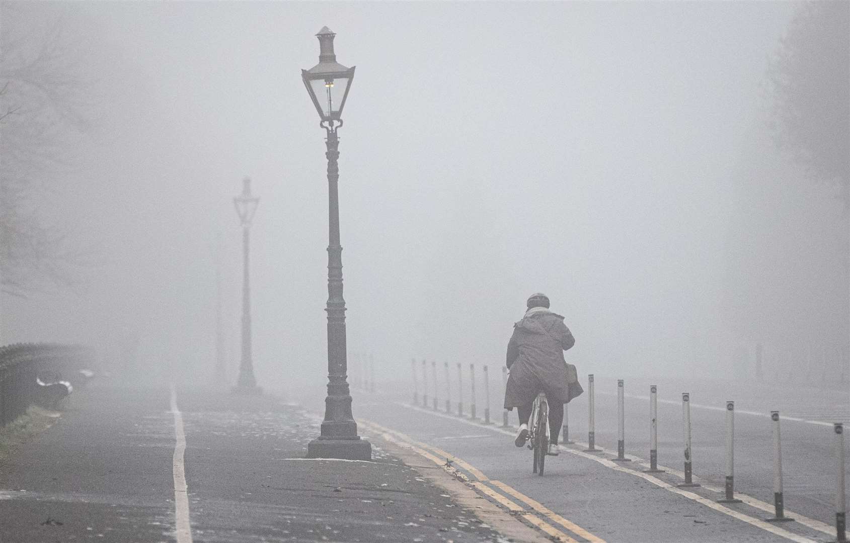 A cyclist navigates thick fog in Dublin as the Irish Met Office issued an orange level freezing fog warning (Damien Storan/PA)