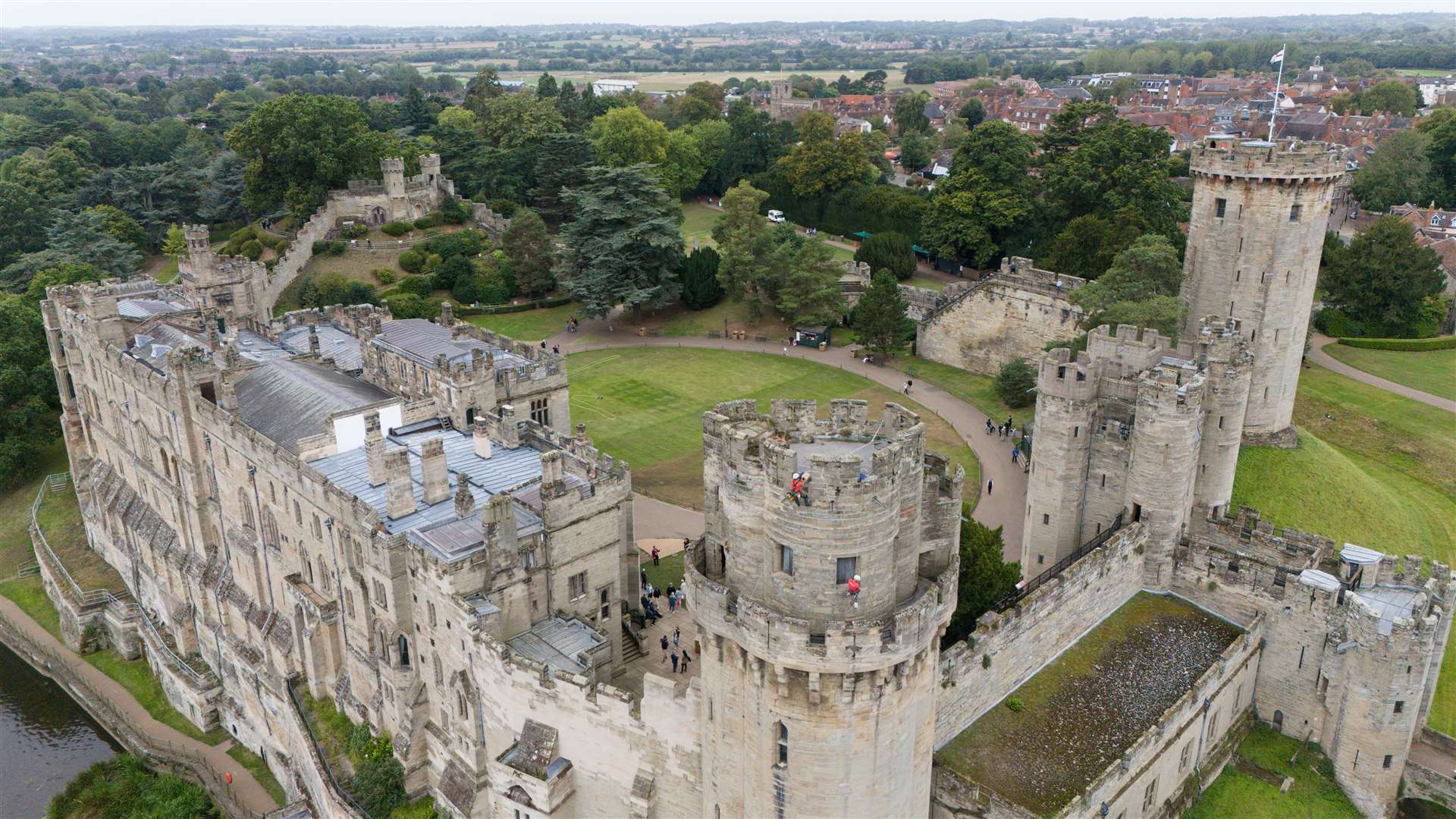 Building restoration specialists abseil down the walls of Warwick Castle’s south front, known as Caesar’s Tower (Jacob King/PA)