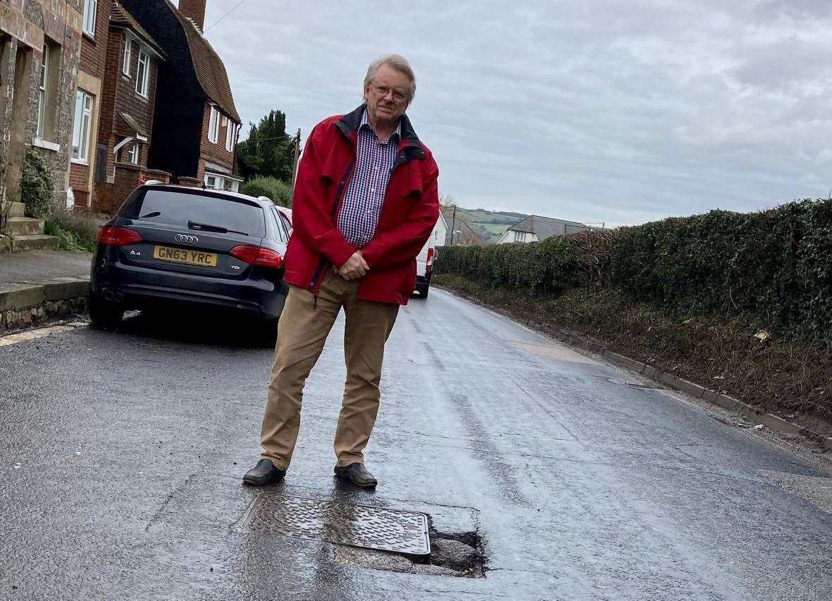 Gary Cooke standing in the B2163 at the site of an earlier pipe-burst