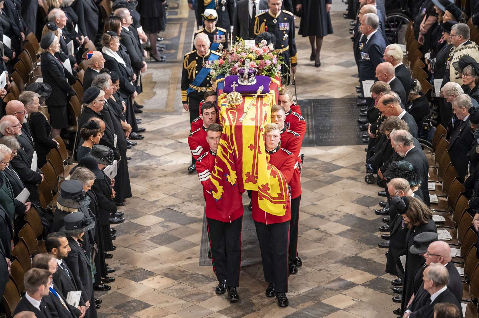 Elizabeth II’s coffin, draped in the Royal Standard with the Imperial State Crown and the Sovereign’s orb and sceptre, is carried out of Westminster Abbey after her state funeral (Danny Lawson/PA)