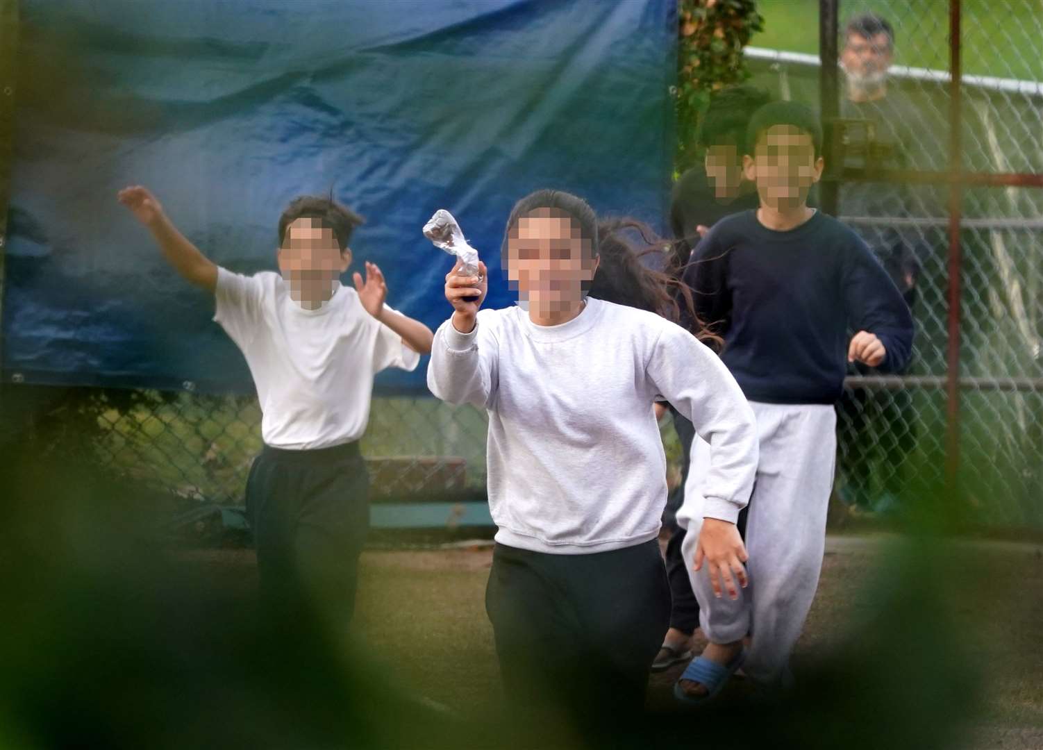 A young girl ran to the fence around Manston migrant processing centre to throw a message in a bottle to a PA news agency photographer (Gareth Fuller/PA)