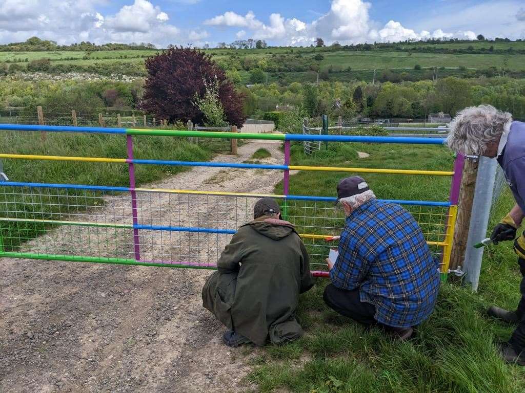 Volunteers painting gates at Nashenden Down to deter metal thieves. Image: Robert Pennington