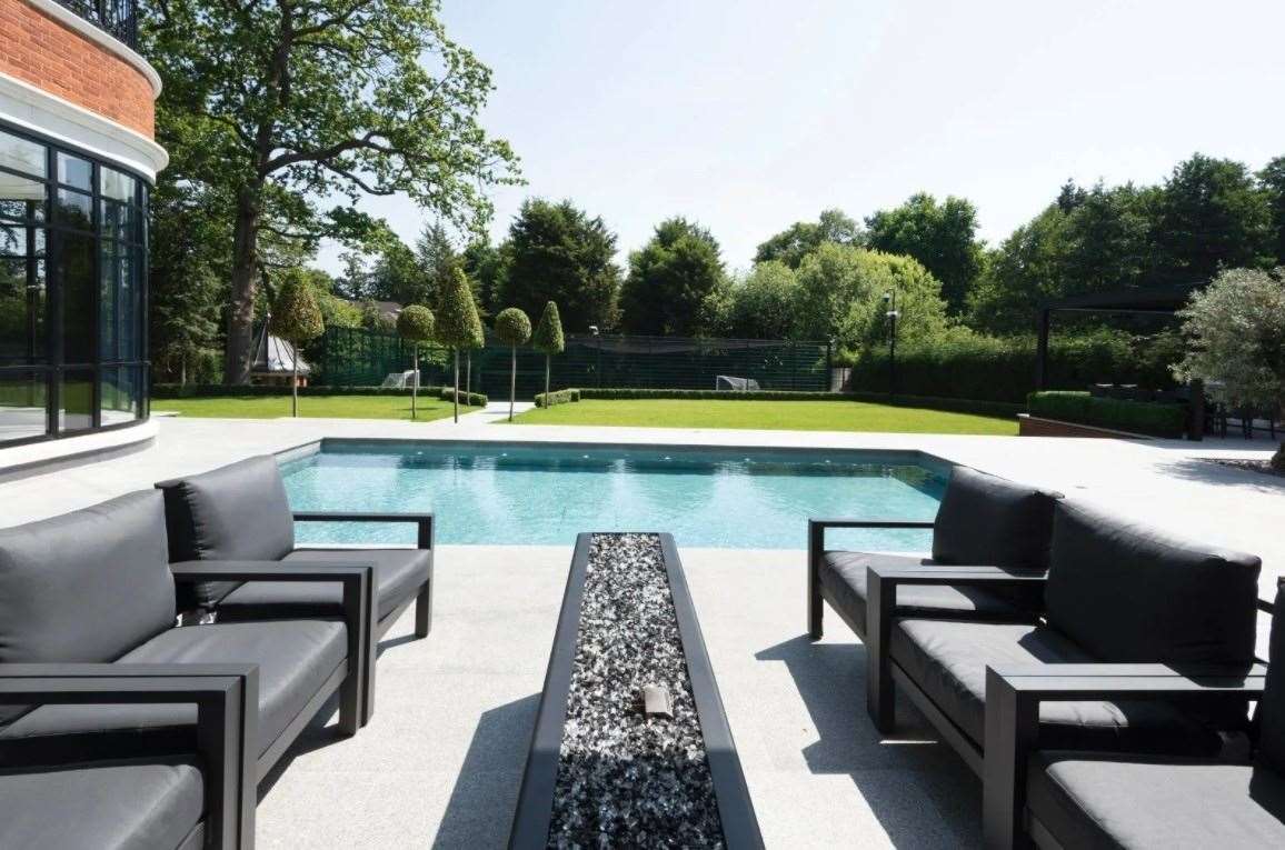 Seating by the pool - with the 4G five-a-side football pitch in the distance. Picture: Zoopla / Strutt & Parker