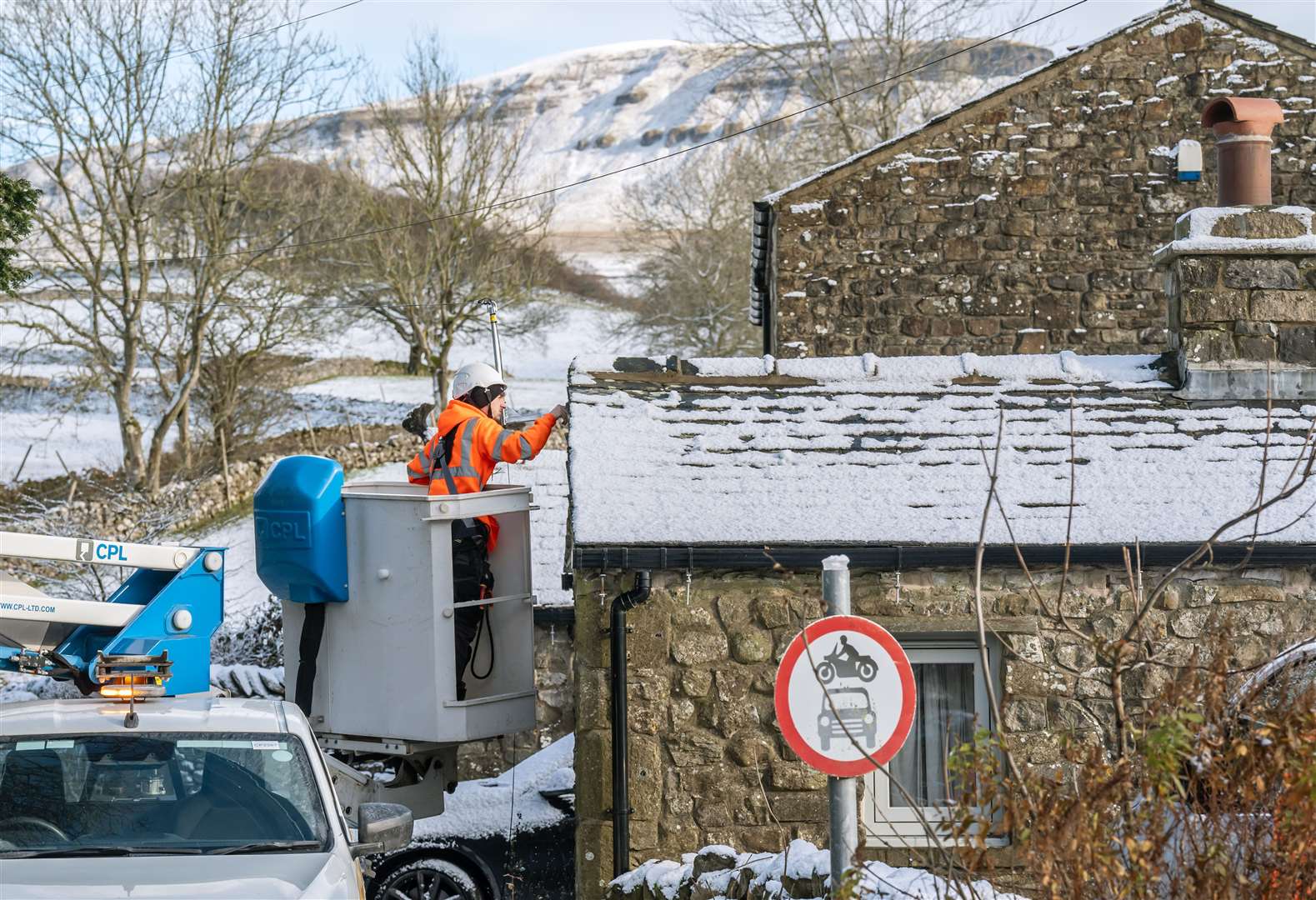 A worker fits an internet cable at a property in Horton in Ribblesdale, North Yorkshire (Danny Lawson/PA)