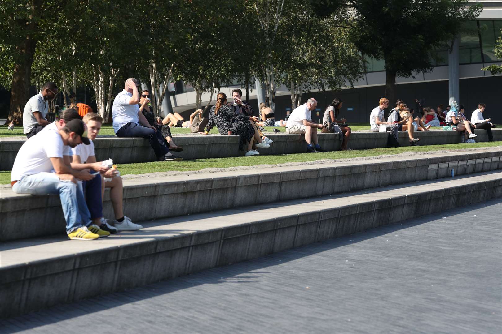 Lunch time visitors observing social distancing rules enjoy the autumn sunshine in Potters Field Park, near City Hall, London (Jonathan Brady / PA)