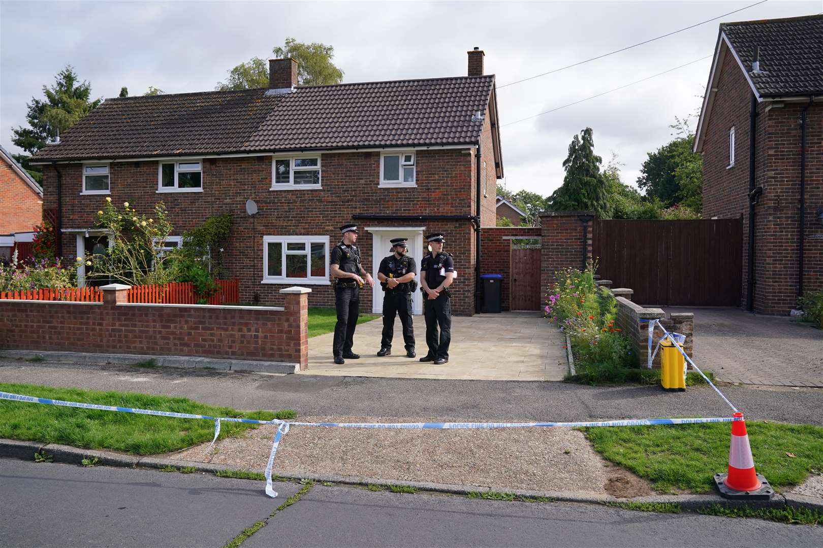 Surrey Police officers outside the property on Hammond Road in Woking (Jonathan Brady/PA)