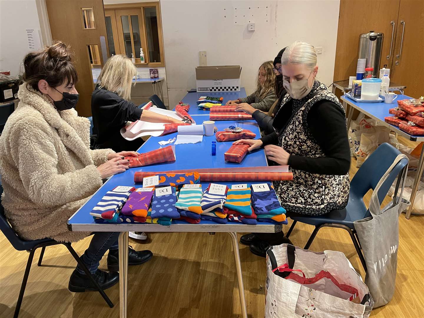 Volunteers wrapping socks to give to guests (Danielle Desouza/PA)