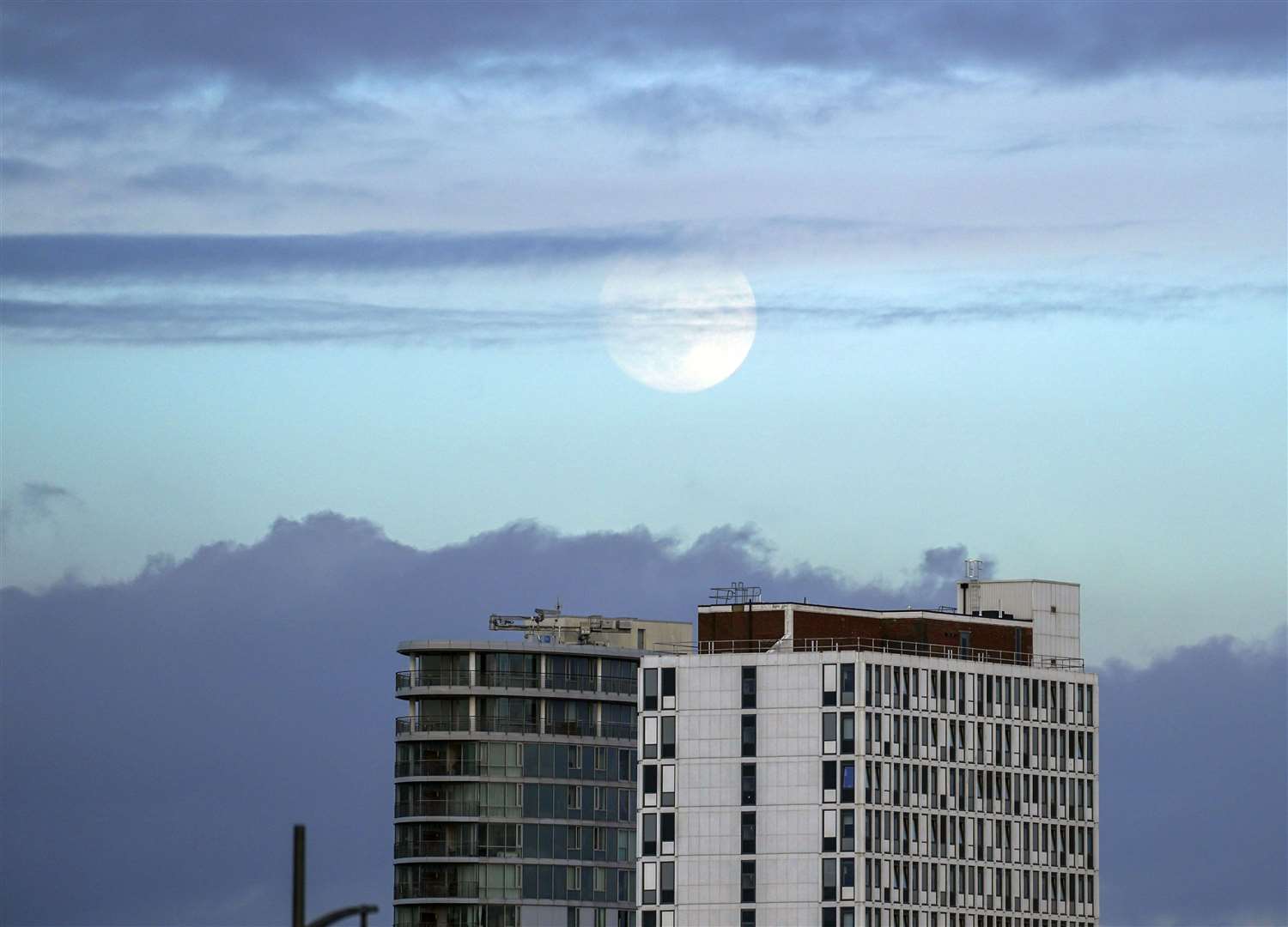 The moon rises above a tower block in Portsmouth (Steve Parsons/PA)