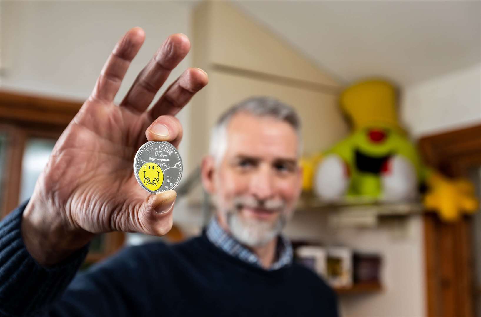 Adam Hargreaves holding the Royal Mint’s new £5 Mr Happy coin (Ciaran McCrickard/PA)