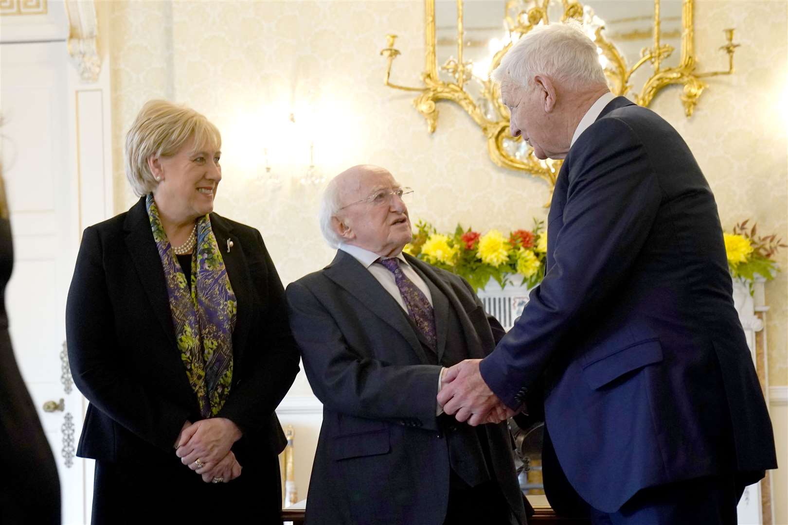 President Michael D Higgins shakes the hand of Sylvester Poff’s great-grandson Tomo Burke after signing a Presidential pardon for Mr Poff and James Barrett (Brian Lawless/PA)