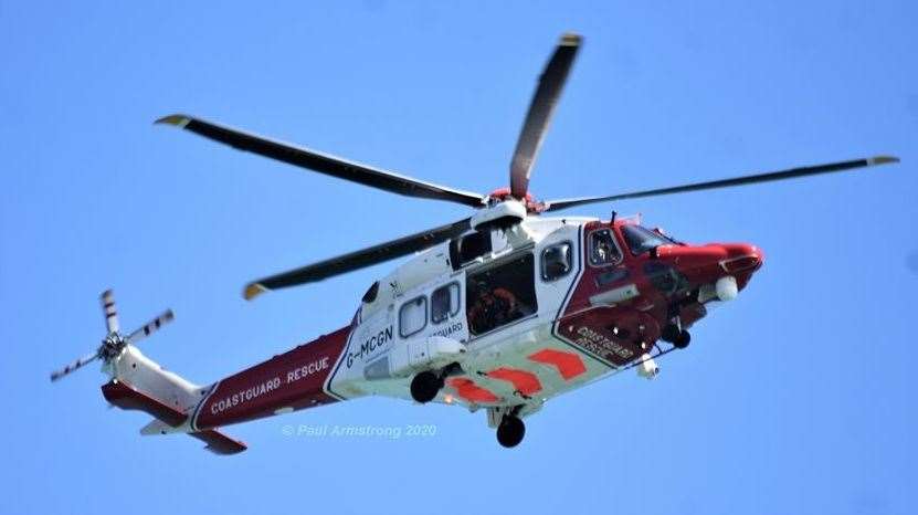 A crew member peers out of the Coastguard helicopter as it searches the sea off Dover. Picture: Paul Armstrong