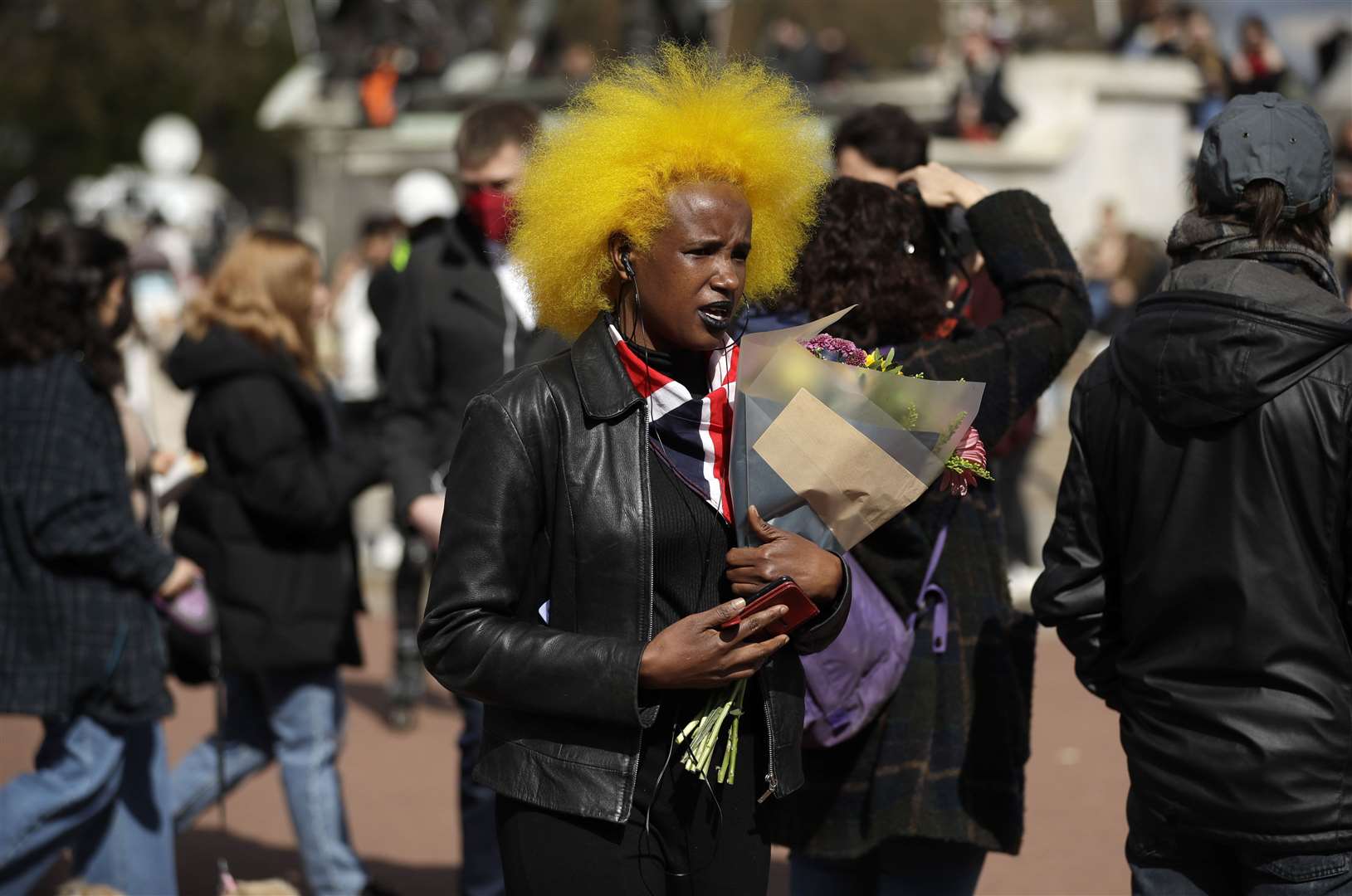 A woman leaves flowers in front of Buckingham Palace (Matt Dunham/PA)